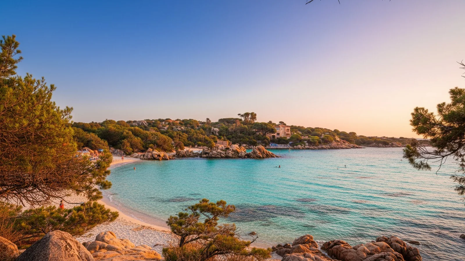 Una caletta di sabbia chiara e acqua turchese fra le rocce e i pini della Costa Smeralda