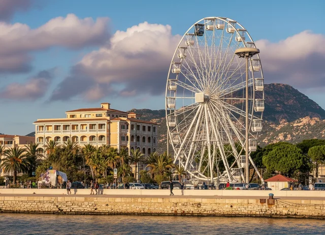 Il lungomare di Olbia al tramonto, con la ruota panoramica e i palazzi affacciati sul porto